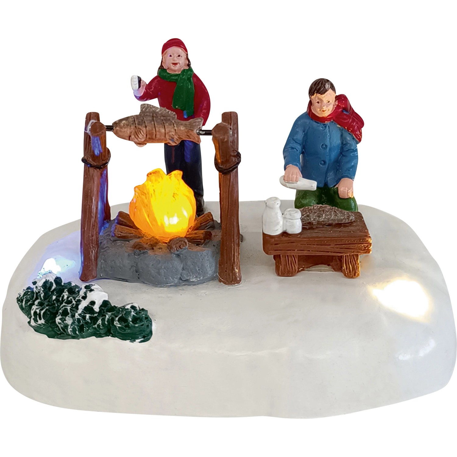 Weihnachtsdorf Grill Camping Szene: Zwei Figuren bereiten Fisch am leuchtenden Lagerfeuer auf Schnee zu. Weihnachtsdekoration.