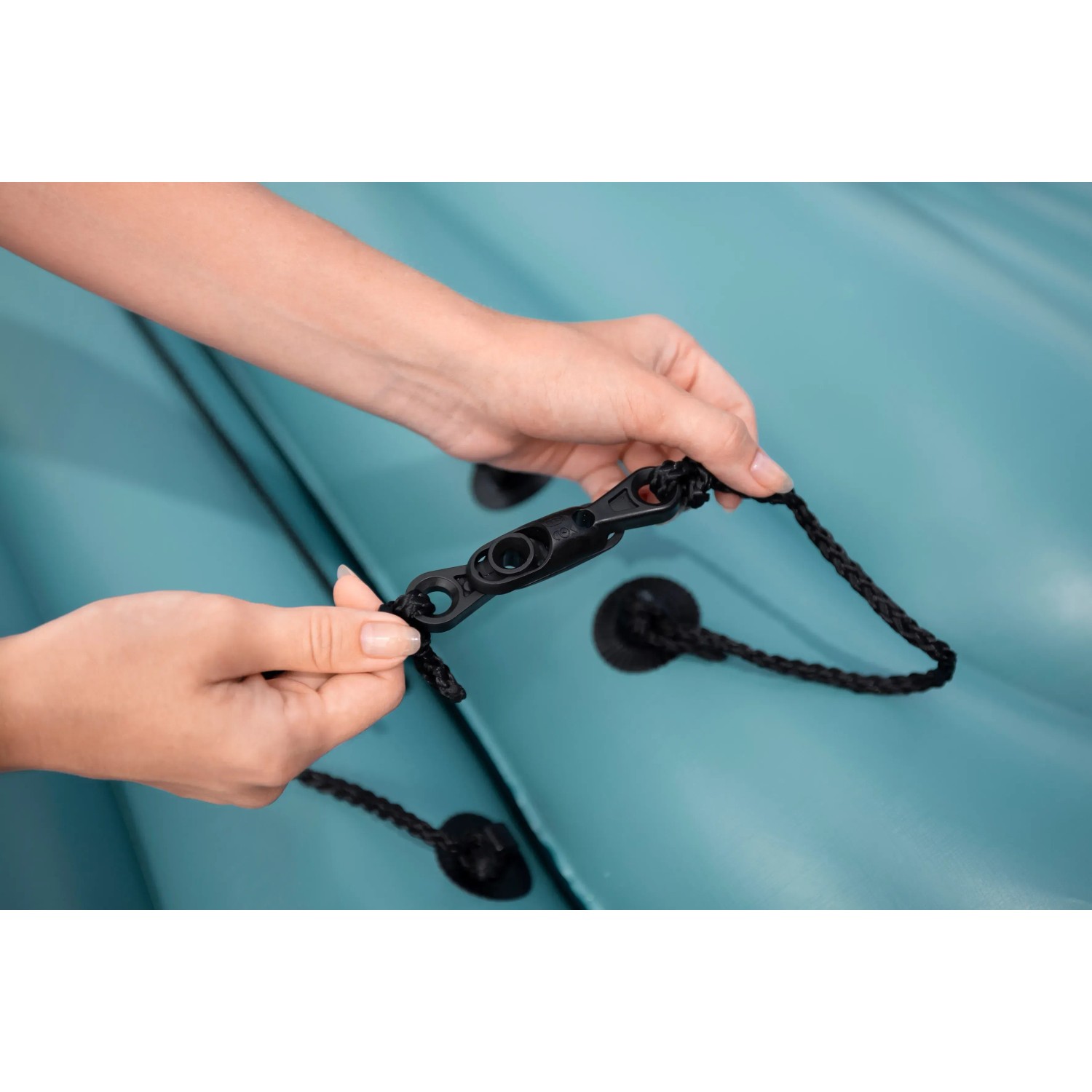 Detailaufnahme: Person befestigt Seil an Bestway Hydro Force Sun Soaker Plattform, Verbindungselement.