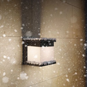 Schwarze Philips Solar-Außenwandleuchte Diara an einer Wand mit Schnee.
