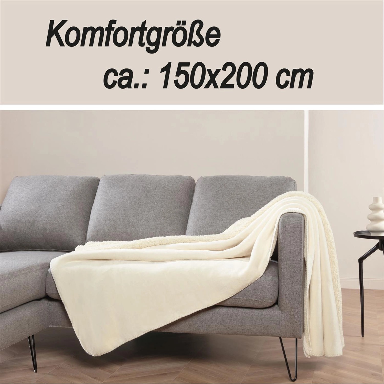 Cremefarbene Bestlivings Kuscheldecke (150x200 cm) aus Teddy Fleece und Sherpa auf grauem Sofa.