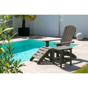 Braungrauer NEG Adirondack Gartenstuhl MARCY aus Kunststoff in Holzoptik mit Fußhocker und Beistelltisch am Pool.