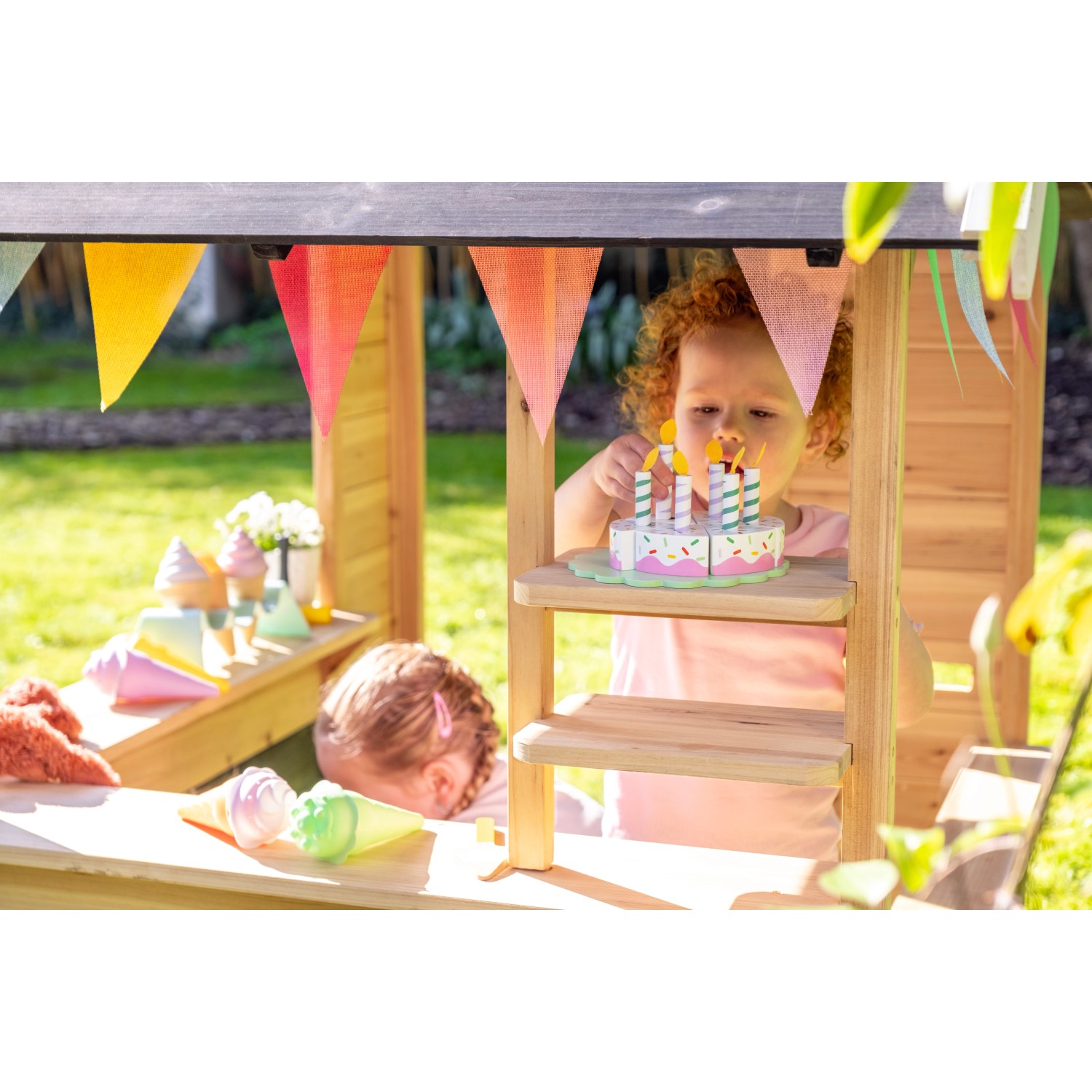 Exit Holzspielhaus Hika mit Kindern beim Rollenspiel im Garten.