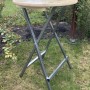 Klappbarer Stehtisch für Garten und Terrasse mit Holzplatte und Metallgestell.