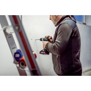 Mann bohrt mit Metabo Akku-Schlagbohrschrauber SB 18 L BL in Wand. Leiter im Bild.