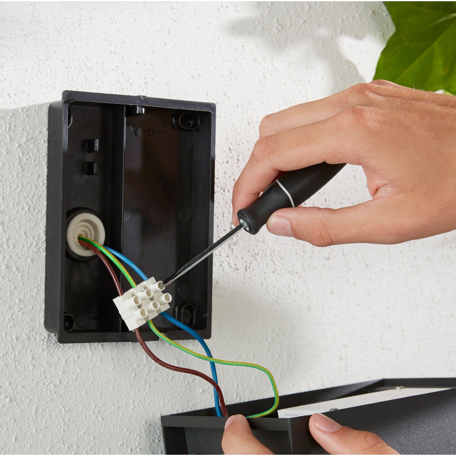 Installation der Philips Hue LED-Außenwandleuchte Resonate in Silber mit Schraubendreher.