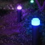 Philips Hue Calla Sockelleuchte im Garten mit farbigem Licht.