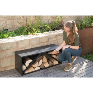 Schwarzes Westmann Kaminholzregal (104x34,5x40cm) mit Holzscheiten und einer Frau davor.