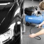 Blauer Güde Kompressor 405/10/50 beim Aufpumpen eines Autoreifens in Werkstatt.