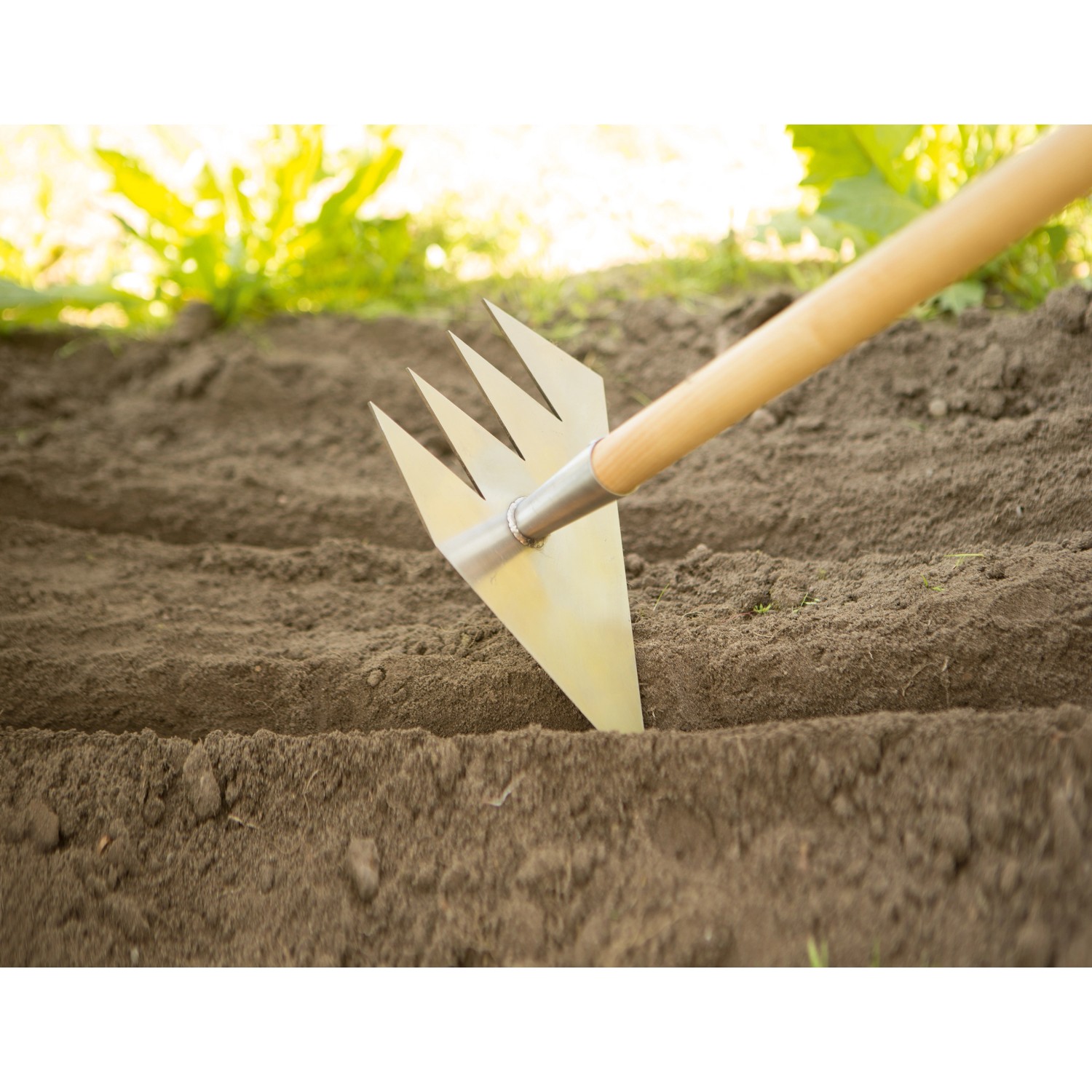 Ruwi Multi-Harke 8in1 aus Edelstahl bei der Bodenbearbeitung im Garten.