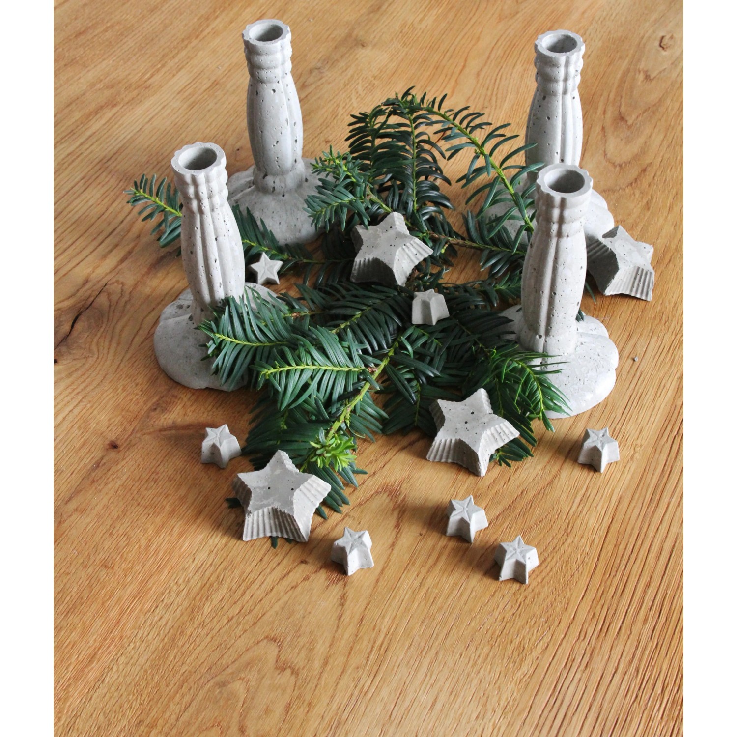 Dekorative Beton-Elemente: Kerzenständer und Sterne aus Ultrament Bastel Beton, hellgrau, mit Tannenzweigen.