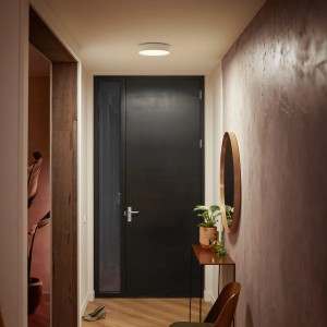 Weiße, runde Philips Hue Enrave Deckenleuchte mit Dimmer im Flur.