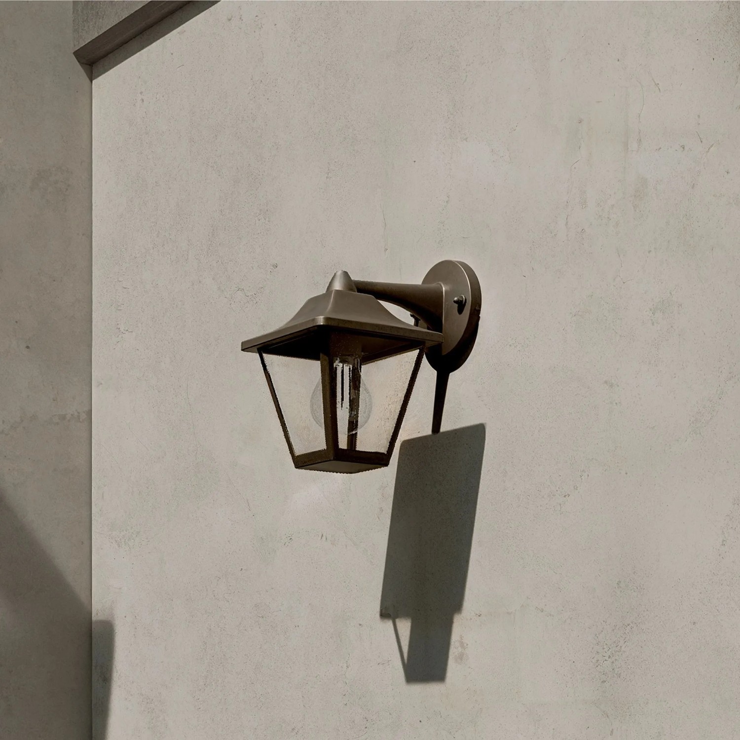 Schwarze Philips Outdoor-Wandleuchte Juli im Laternen-Design an einer Wand.