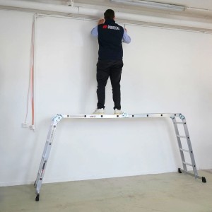 PROREGAL Mehrzweckleiter MULTISTEP als Arbeitsgerüst mit Person auf Plattform, Aluminium, 4x4 Sprossen.