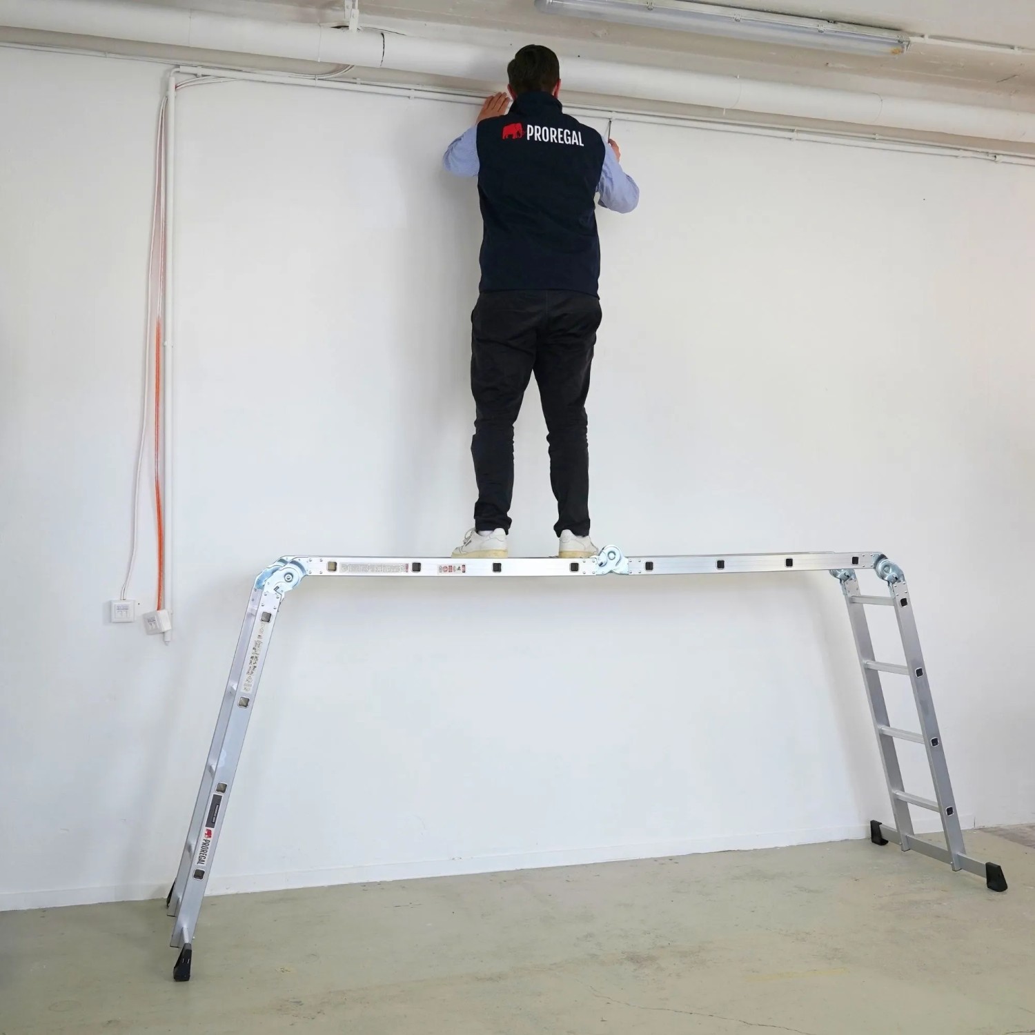 PROREGAL Mehrzweckleiter MULTISTEP als Arbeitsgerüst mit Person auf Plattform, Aluminium, 4x4 Sprossen.