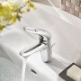 Glänzende Grohe Eurostyle Waschbeckenarmatur S-Size Chrom mit Wasserstrahl im weißen Waschbecken.