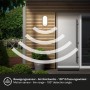 Schwarze Briloner LED Wandleuchte mit Bewegungsmelder an Hauswand. Außenleuchte, IP65.