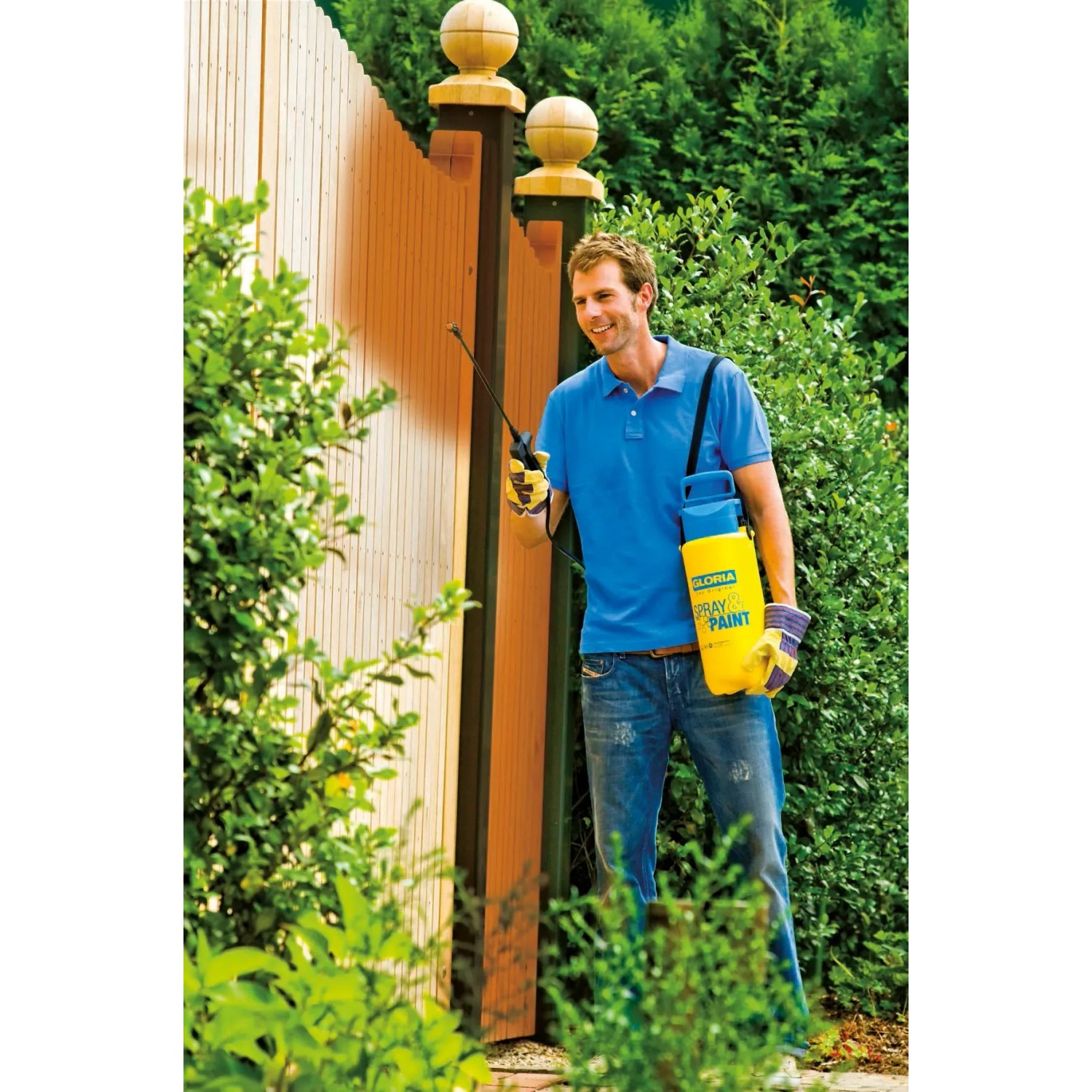 Mann nutzt Gloria Drucksprüher Spray&Paint 5 l zum Lasieren eines Holzzauns.