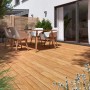 Terrasse mit Douglasie Terrassendielen, strukturgehobelt, mit Gartenmöbeln. Warmer, rötlicher Farbton.