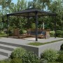 Palram Canopia Martinique Gartenpavillon 3x3.6 m in Anthrazit/Bronze mit Sitzgruppe im Garten.