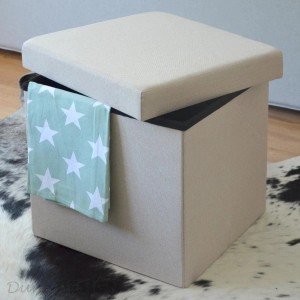 Beige-grauer DuneDesign Sitzwürfel mit Stauraum, teilgeöffnet mit Tuch. Gartenstuhl.