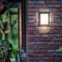 Philips myGarden LED-Außenwandleuchte Karp, anthrazitfarbene Wandlampe an Backsteinmauer.