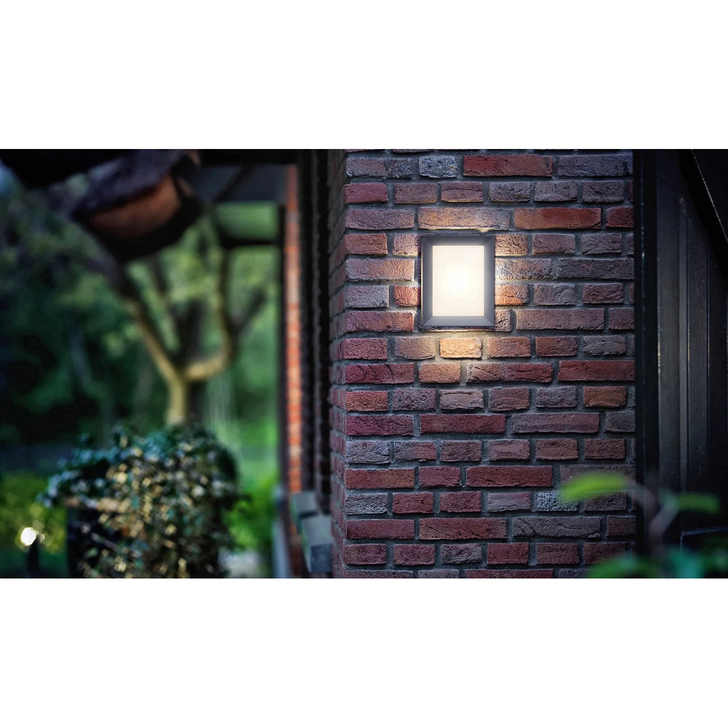 Philips myGarden LED-Außenwandleuchte Karp, anthrazitfarbene Wandlampe an Backsteinmauer.
