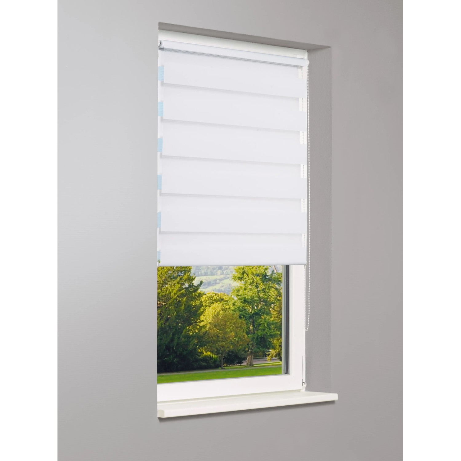 Weißes Vario-Rollo Sedano, 100x150 cm, am Fenster mit Blick ins Grüne.