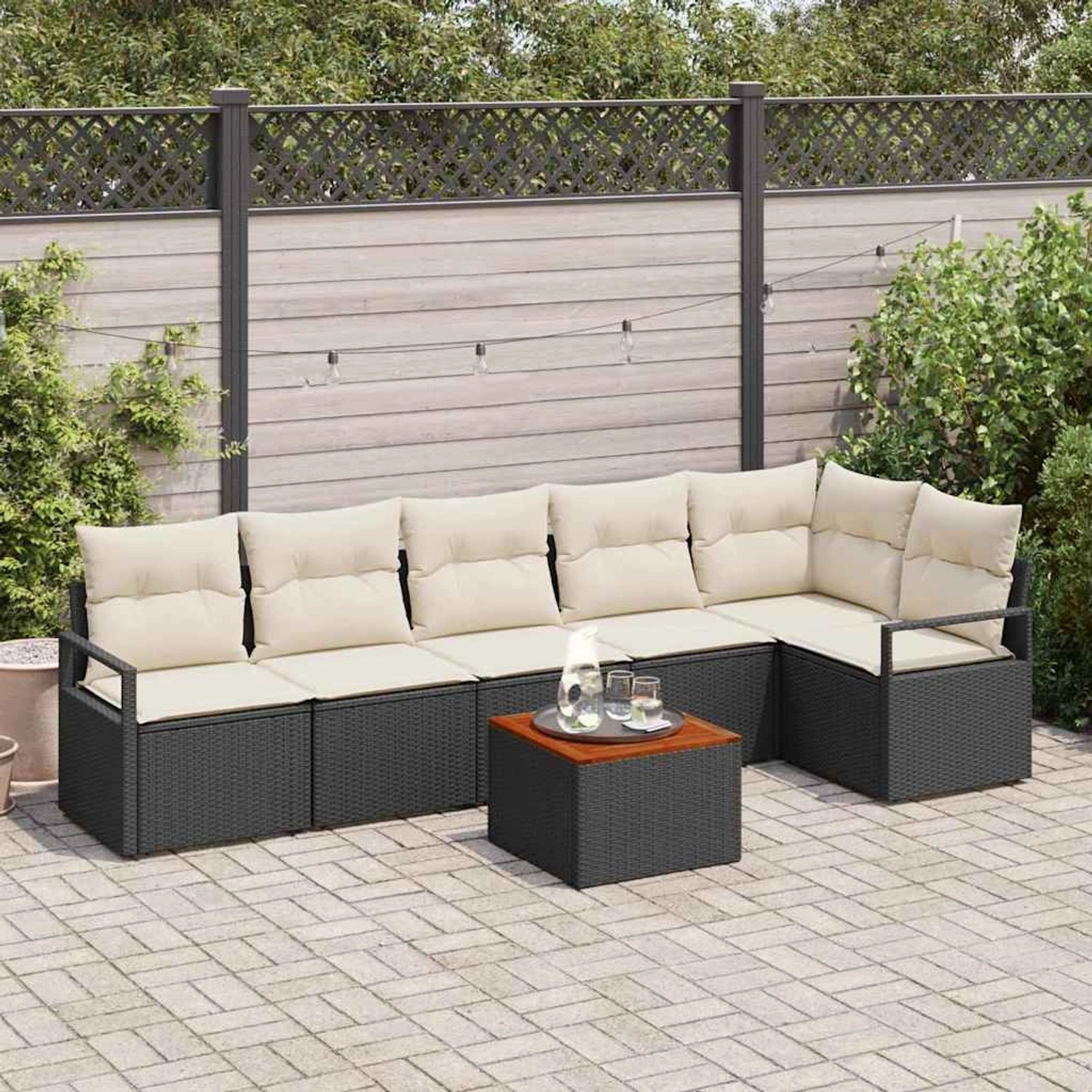 Schwarzes 7-teiliges Garten-Sofa-Set aus Poly Rattan mit Kissen und Tisch.