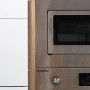 Detailaufnahme: Respekta Premium Küchenzeile mit Mikrowelle und Backofen in Edelstahloptik, eingebaut in Eiche Sägerau Dekor.