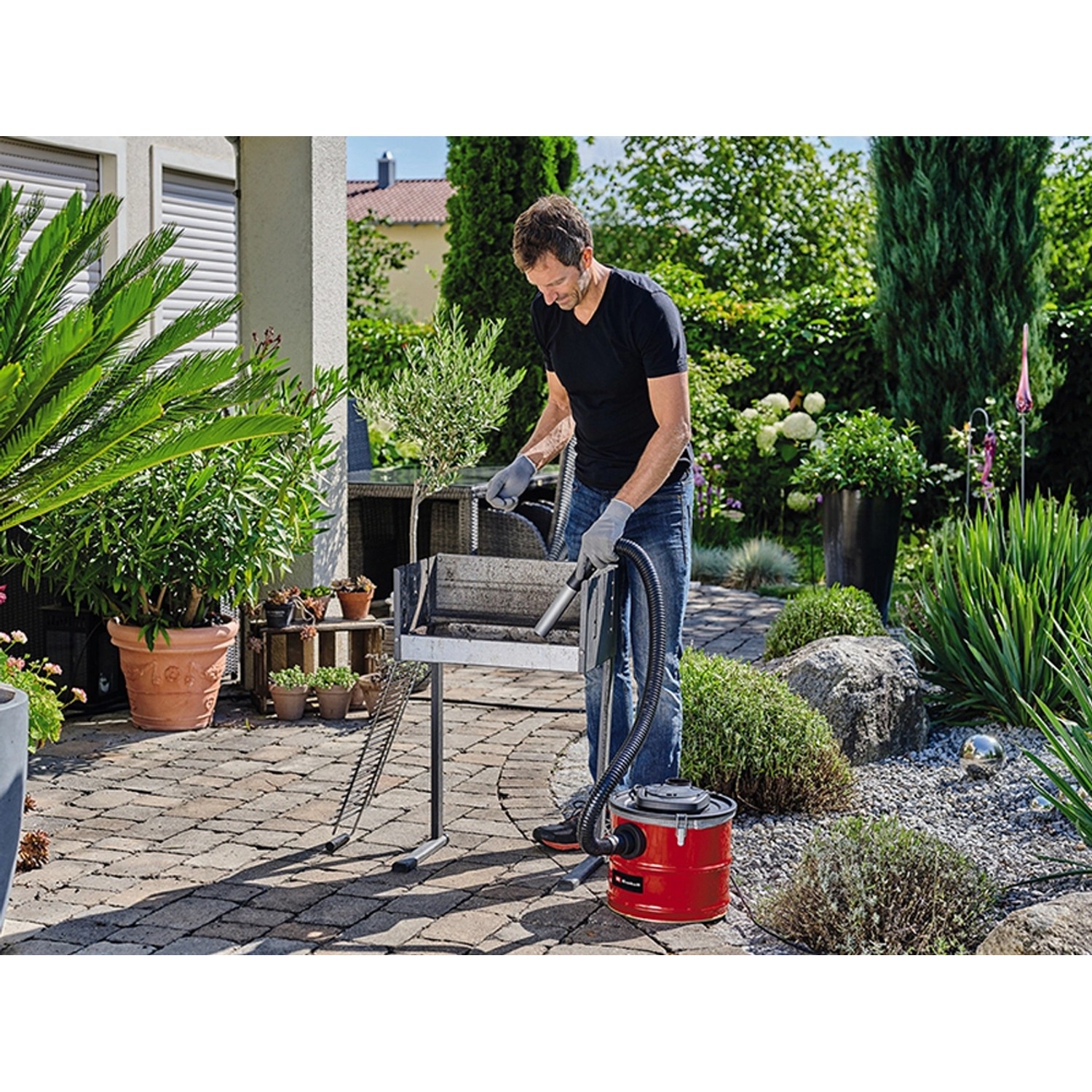 Mann reinigt Grill mit Einhell Aschesauger TC-AV 1718 D (1200 W).