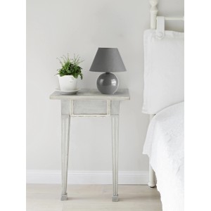 Graue Keramik Tischleuchte mit Stoffschirm auf Nachttisch. Dekorative Nachttischlampe.