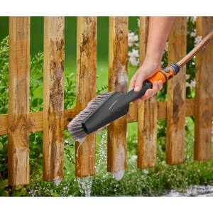 Gardena Cleansystem Handbürste M soft mit Schlauch reinigt Holzzaun.