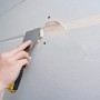 Anwendung von Knauf Uniflott Spachtelmasse auf einer Gipskartonplatte mit einem Spachtel.