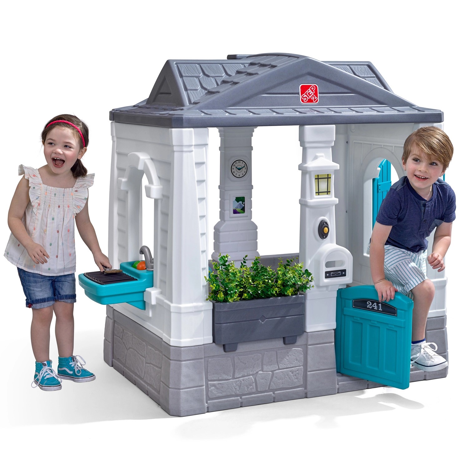 Step2 Spielhaus Neat & Tidy Cottage Homestyle Edition mit spielenden Kindern.