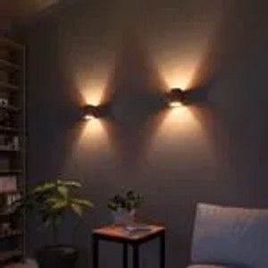 Zwei runde, schwarz-goldene Wandleuchten für Up-Down-Lichteffekte im Wohnraum.