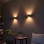 Zwei runde, schwarz-goldene Wandleuchten für Up-Down-Lichteffekte im Wohnraum.