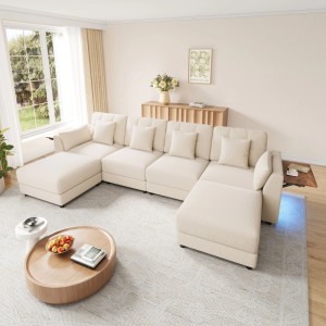 Beiges U-förmiges Ecksofa aus Chenille mit LED-Beleuchtung und integriertem Holztisch in einem Wohnzimmer.