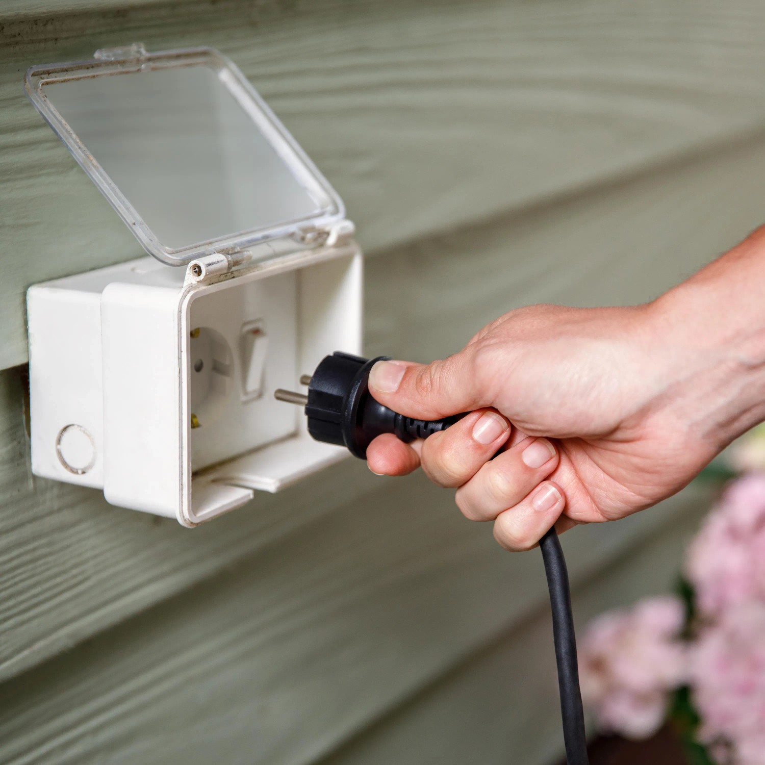 Einstecken des Philips Hue Outdoor-Netzteils in eine Außensteckdose.