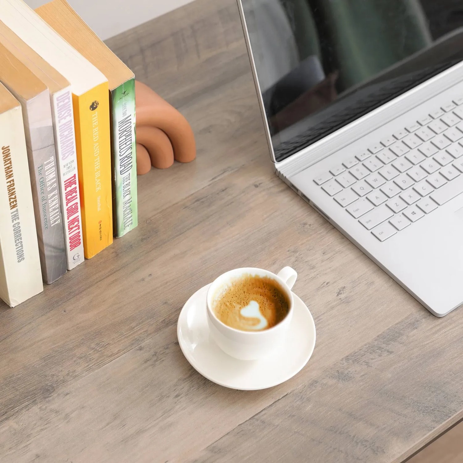 Vasagle Computertisch schwarz mit Laptop, Kaffee und Büchern auf der Tischplatte.
