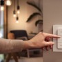 Philips Hue Dimmschalter in Weiß wird von einer Hand bedient, um die Lichtstimmung zu ändern.