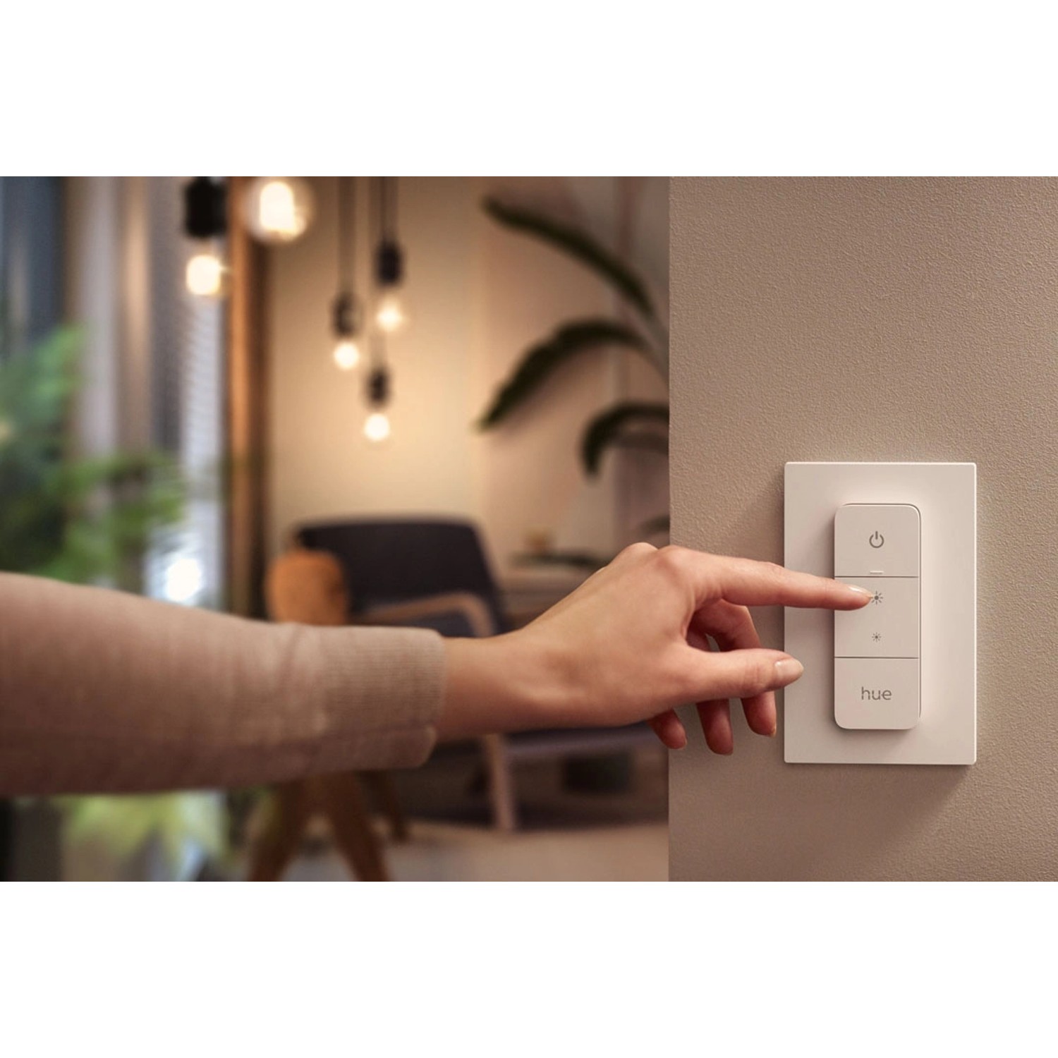 Philips Hue Dimmschalter in Weiß wird von einer Hand bedient, um die Lichtstimmung zu ändern.