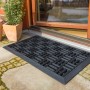Schwarze Astra Gummimatte Dynamic 40x60 cm vor einer Haustür. Fußmatte für den Außenbereich.