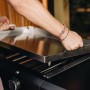 Enders Plancha-Grill Amaro 2: Person setzt Edelstahl-Grillplatte auf Gasgrill.