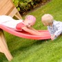 Kinder spielen auf der roten Rutsche des Axi Tom Spielhauses im Garten.