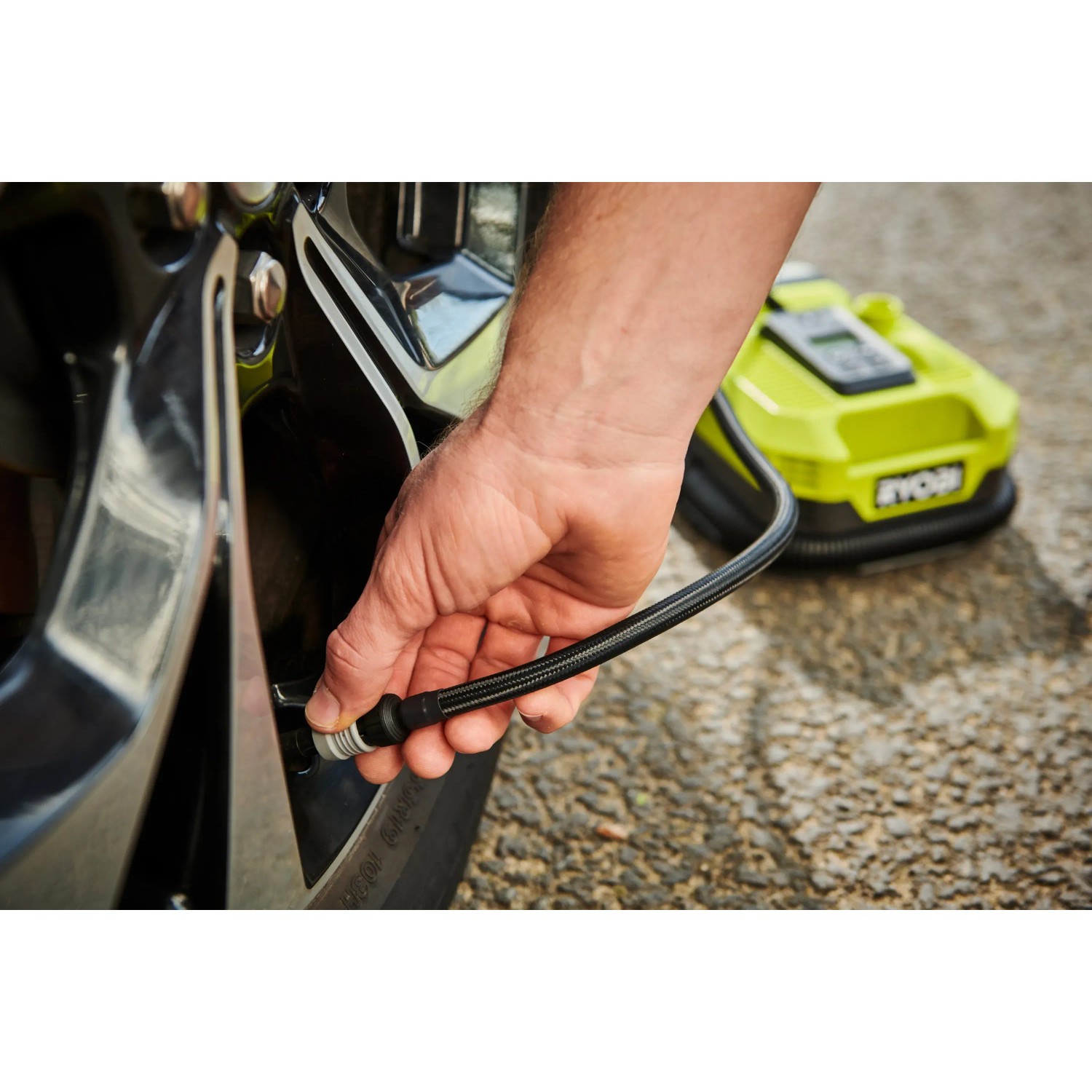 Ryobi Akku-Multi-Kompressor beim Aufpumpen eines Autoreifens.