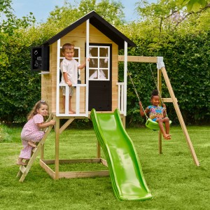 Zwerkules Spielhaus Holli mit Rutsche und Schaukel im Garten mit spielenden Kindern.