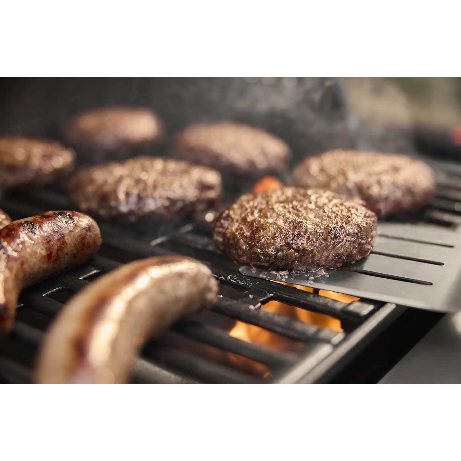 Grillgut auf Weber Gasgrill: Burger und Würstchen werden gegrillt.