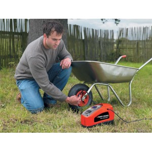 Black+Decker ASI300 Elektro-Pumpe beim Aufpumpen eines Schubkarrenreifens im Garten.
