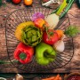 Schwarze Relaxdays Obstschale aus Eisen, offen, gefüllt mit frischem Obst und Gemüse auf Holztisch. Moderner Drahtkorb für Küche.