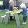 EXIT Aksent Sand-, Wasser- und Picknicktisch mit Kindern beim Spielen im Garten.